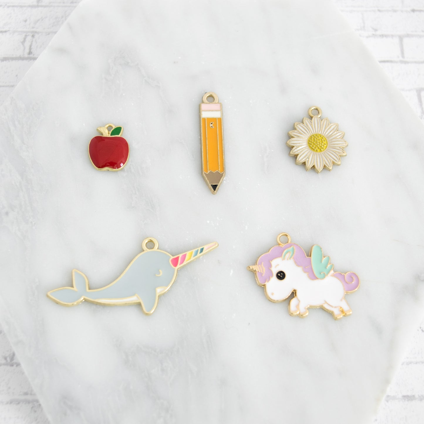 Bookmark colorful enamel charm options include a narwhal, unicorn, pencil, apple, and flower.