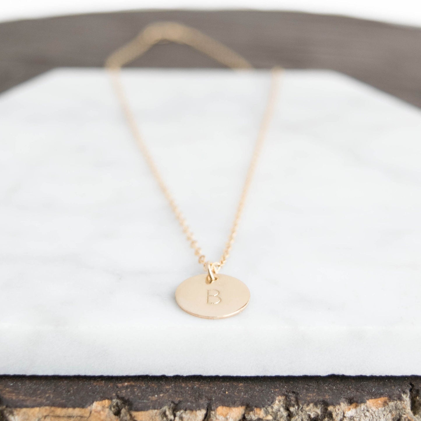 Customize your look with the Aster 1/2" Disc Monogrammed Initial Necklace, a minimalist 14K gold-filled or sterling silver disc necklace delicately hand-stamped with an initial of your choice.