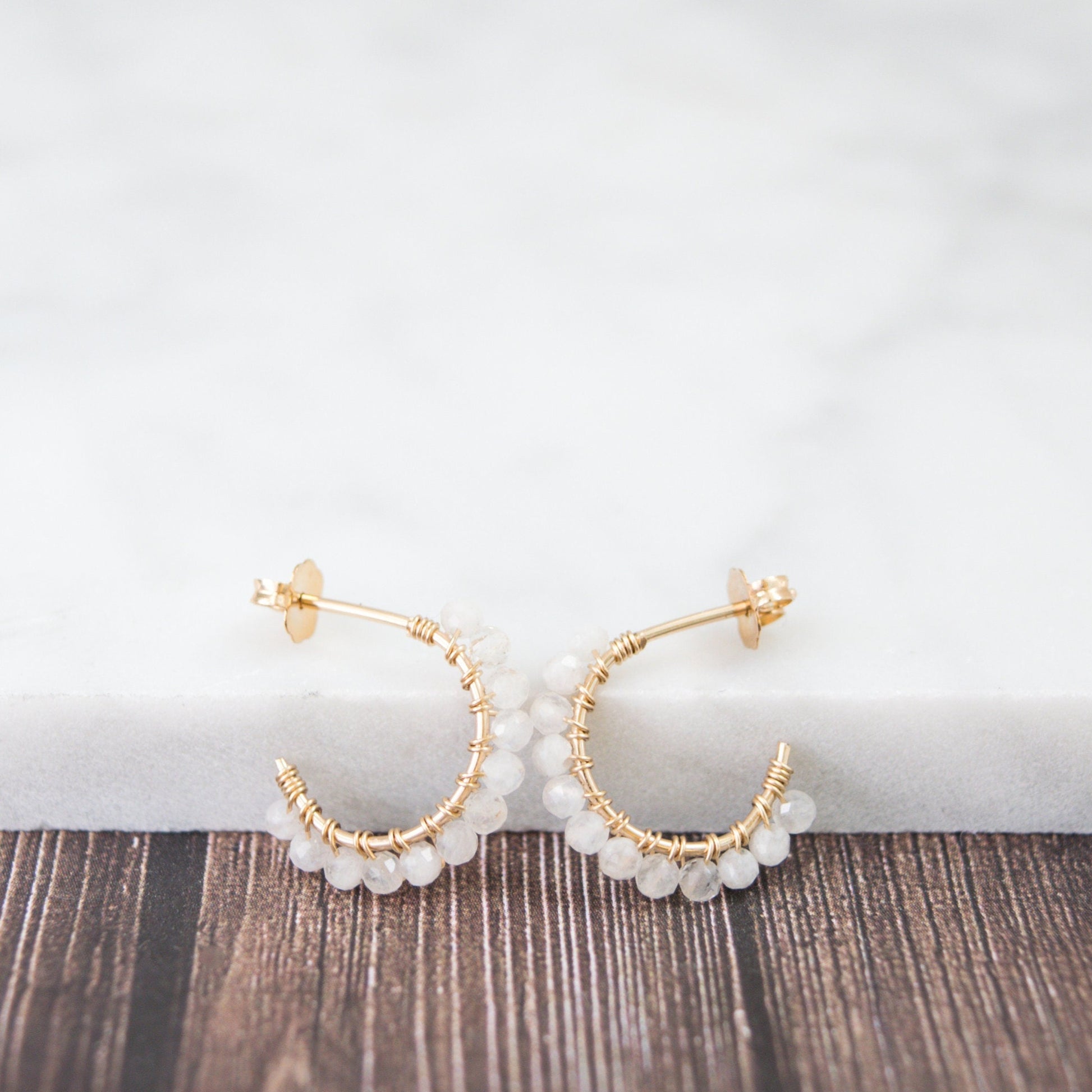 Hand-formed 14k gold-filled wire gracefully shaped into mini rounded hoops. Delicately strung with micro-faceted natural rainbow moonstone beads, these mini hoops add a polished finish to any outfit.