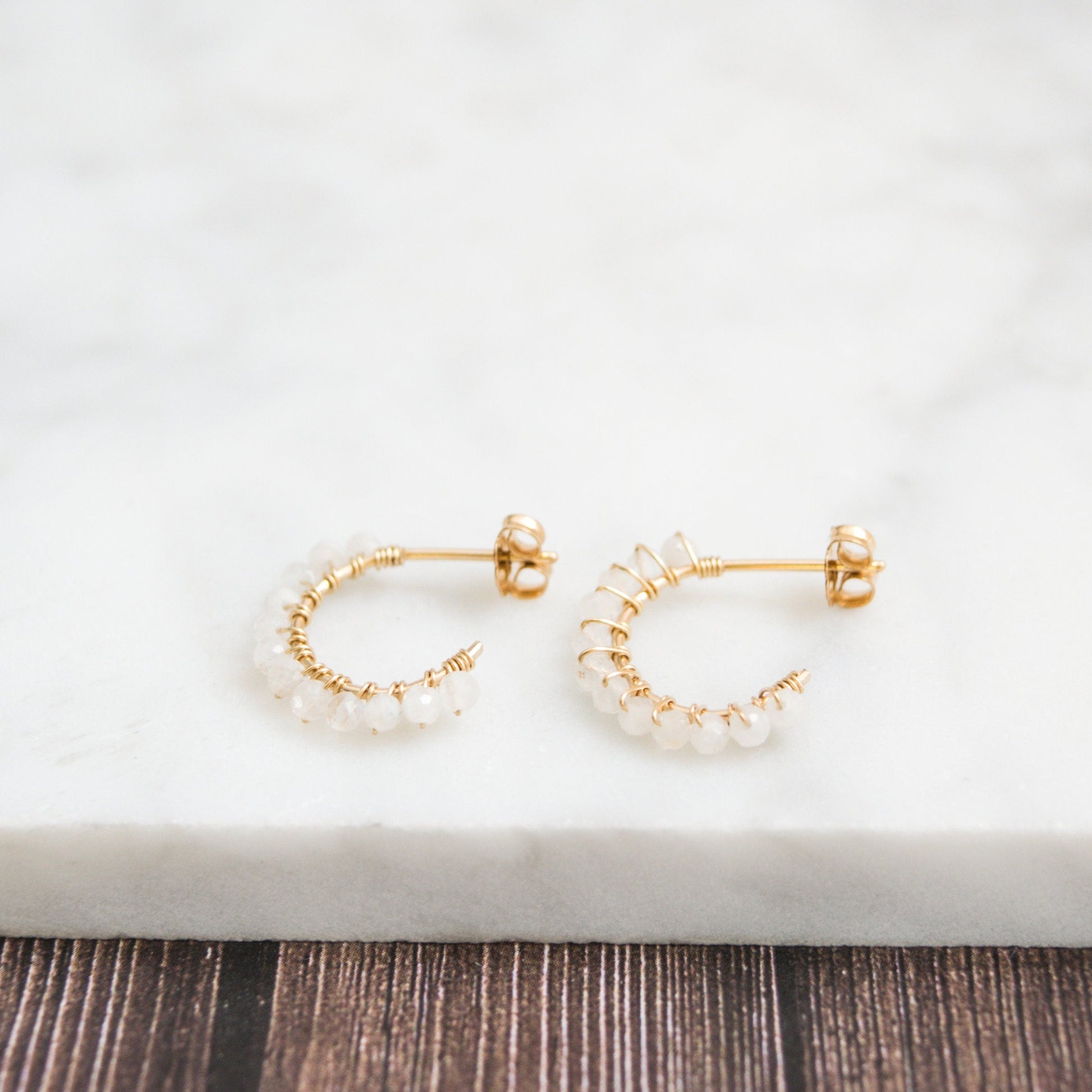 Hand-formed 14k gold-filled wire gracefully shaped into mini rounded hoops. Delicately strung with micro-faceted natural rainbow moonstone beads, these mini hoops add a polished finish to any outfit.