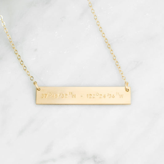 Hand stamped coordinates on a gold filled bar