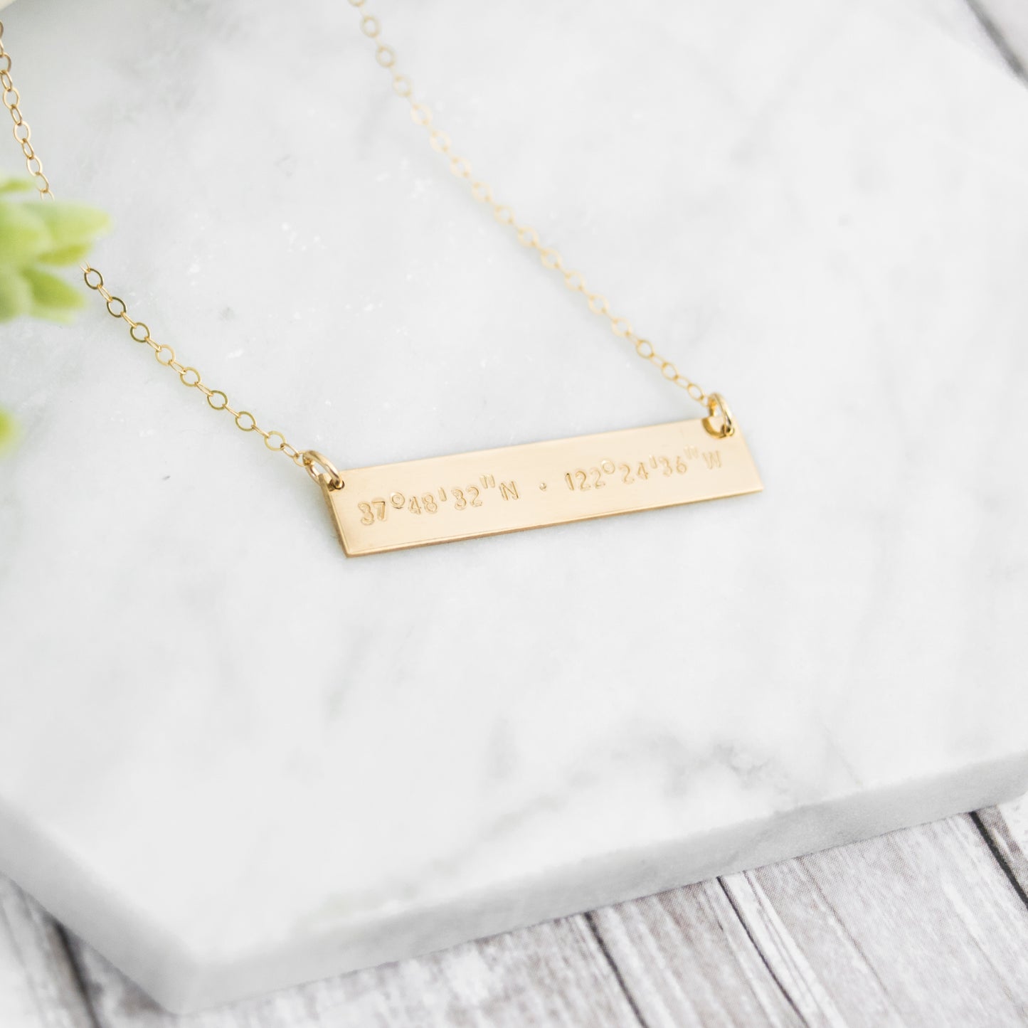 Hand stamped coordinates on a gold filled bar
