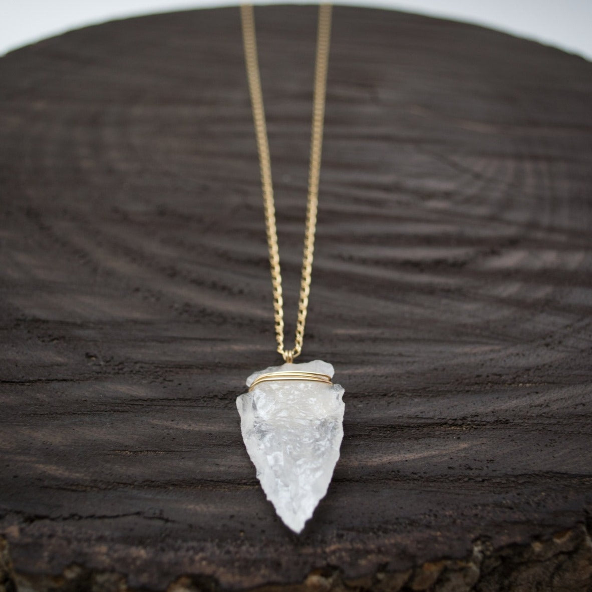 Elevate your style with the Althea Quartz Crystal Necklace, featuring a hand-knapped natural quartz crystal arrowhead on a 14k gold-filled curb figaro chain.