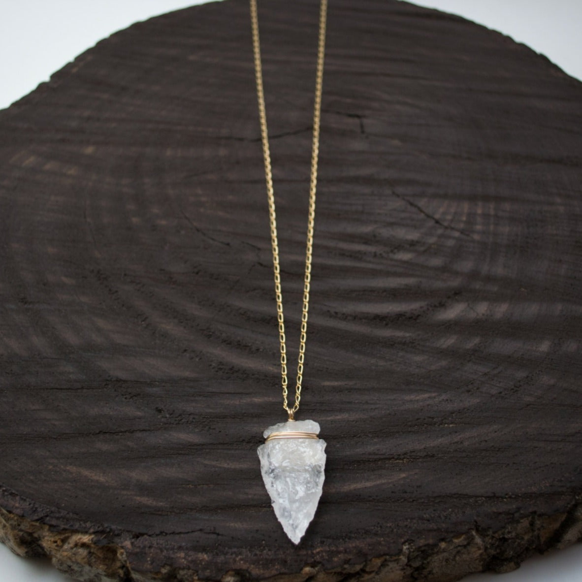 Elevate your style with the Althea Quartz Crystal Necklace, featuring a hand-knapped natural quartz crystal arrowhead on a 14k gold-filled curb figaro chain.