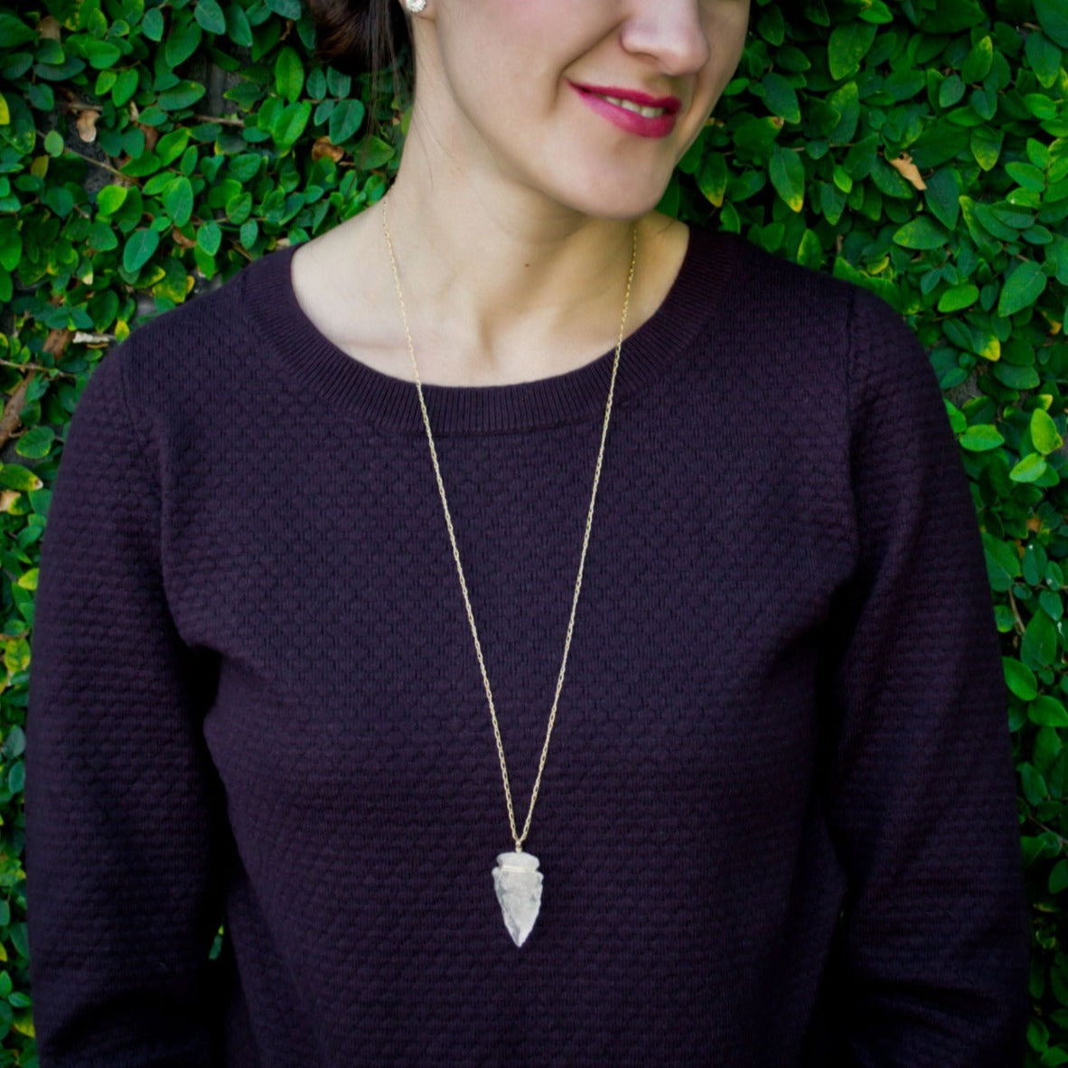 Elevate your style with the Althea Quartz Crystal Necklace, featuring a hand-knapped natural quartz crystal arrowhead on a 14k gold-filled curb figaro chain. Image is necklace on model.