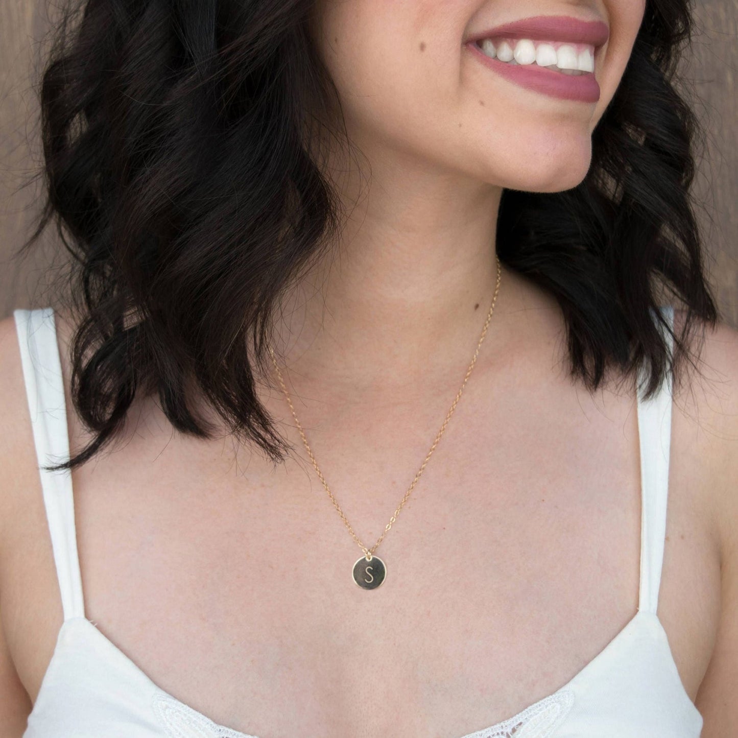 Customize your look with the Aster 1/2" Disc Monogrammed Initial Necklace, a minimalist 14K gold-filled or sterling silver disc necklace delicately hand-stamped with an initial of your choice.