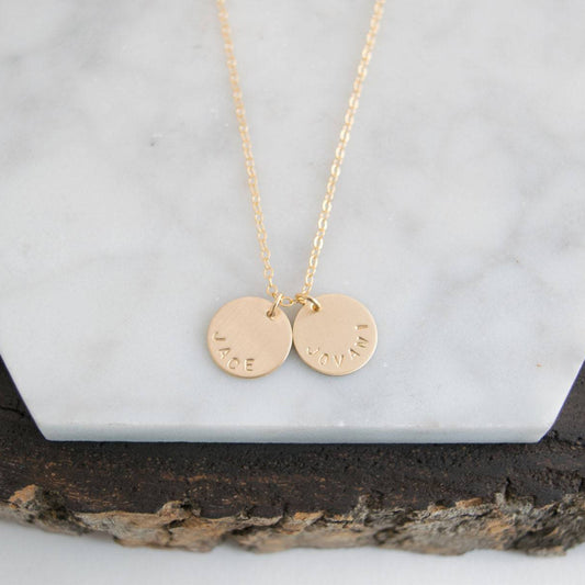 Customize your look with the Aster 1/2" Disc Name Necklace, a minimalist 14K gold-filled or sterling silver disc necklace delicately hand-stamped with a name, message, initials, or date of your choice.
