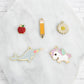 Bookmark colorful enamel charm options include a narwhal, unicorn, pencil, apple, and flower.