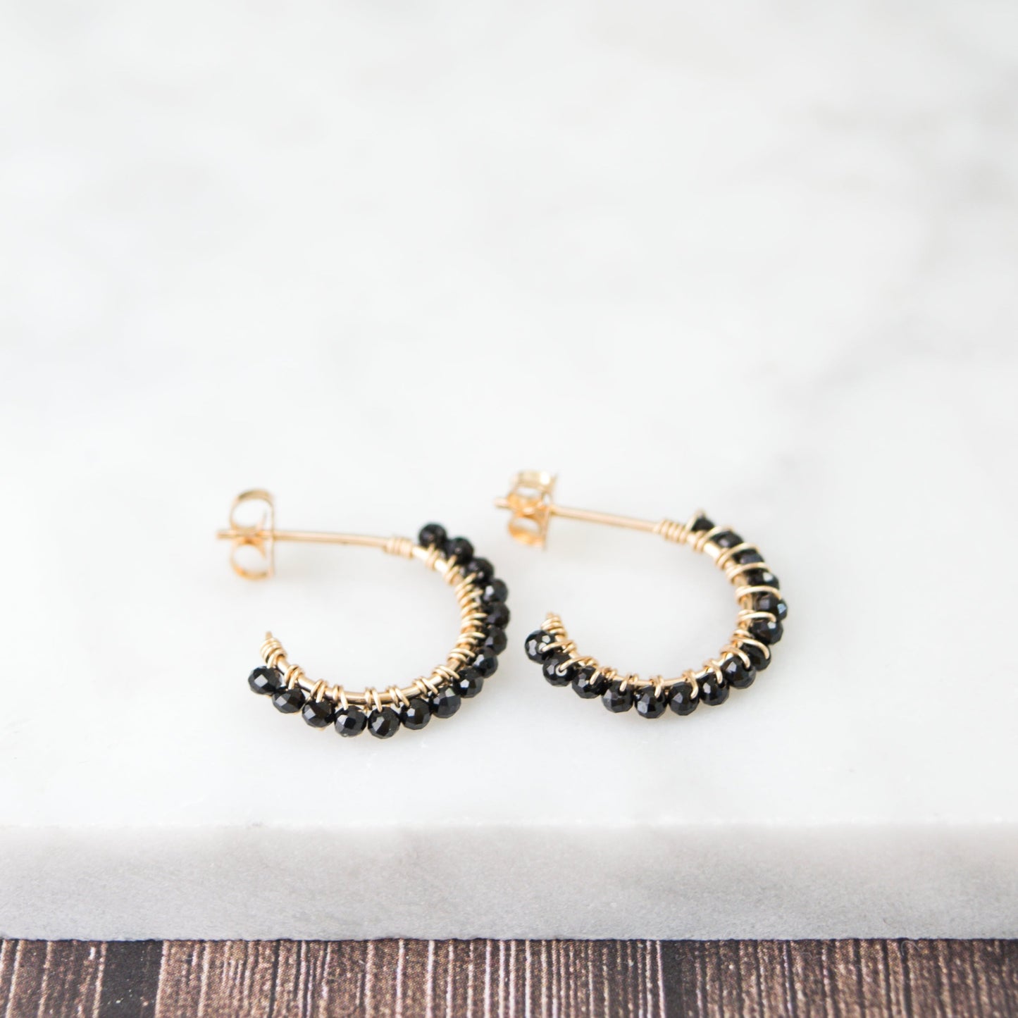 14k gold-filled wire hand formed into a mini rounded hoop with micro faceted natural black spinel beads wire wrapped throughout.