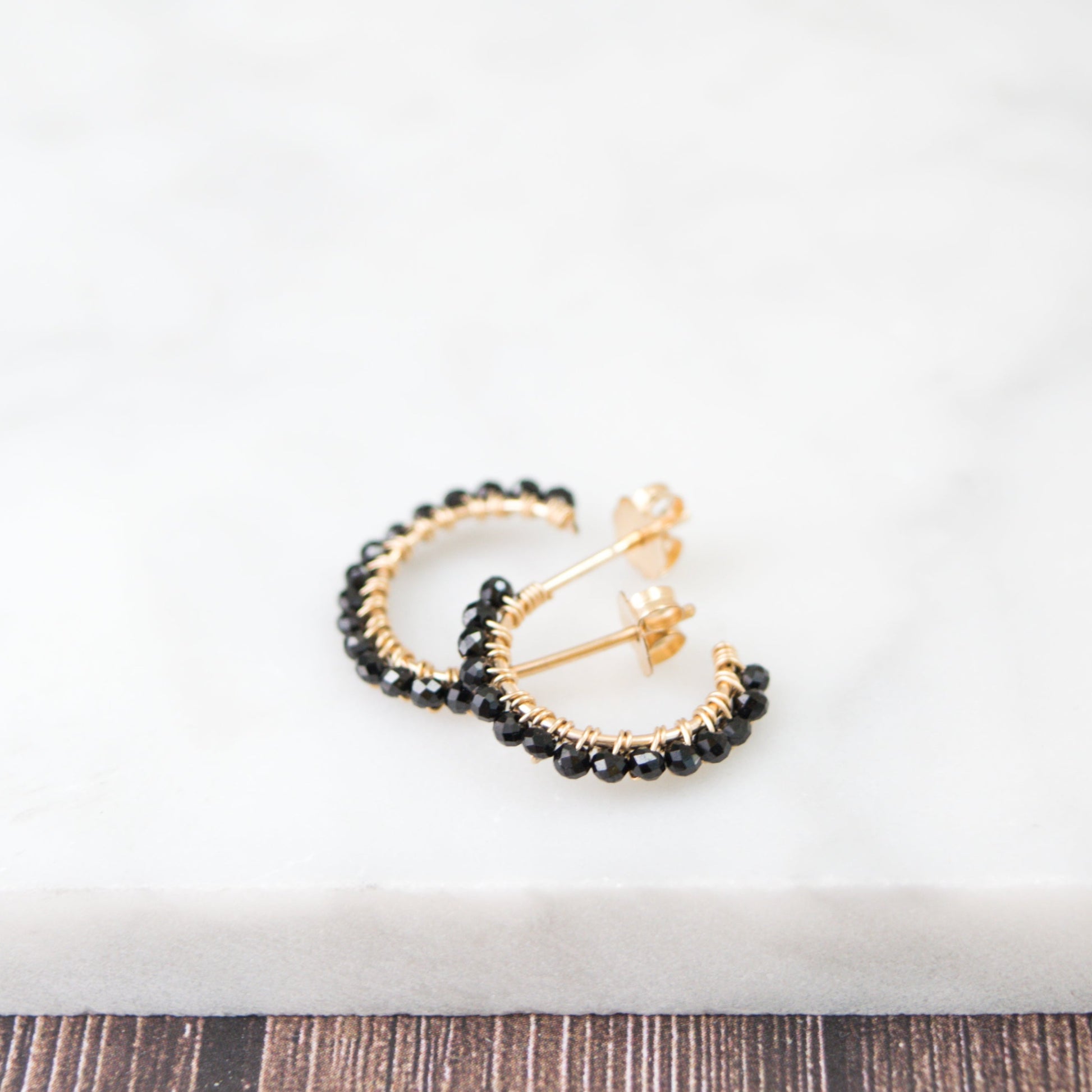 14k gold-filled wire hand formed into a mini rounded hoop with micro faceted natural black spinel beads wire wrapped throughout.