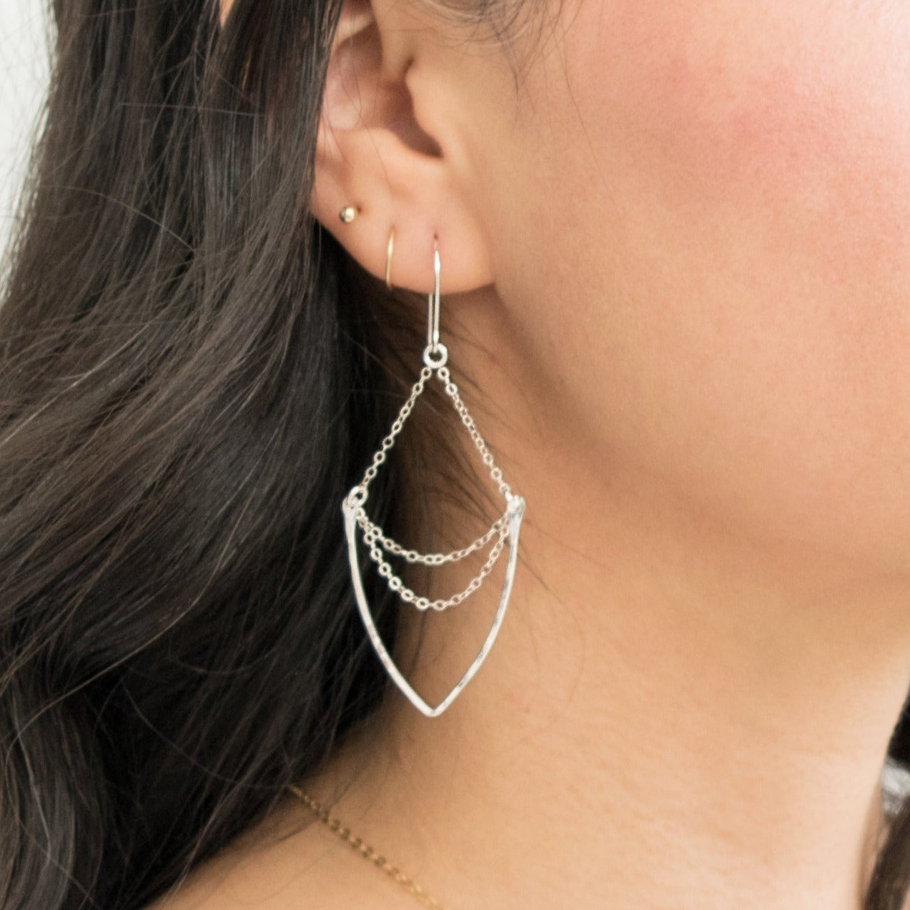 Multi-chain chandelier earrings featuring hammered v-shaped pendant suspended on a 14k gold-filled or sterling silver cable chain. These earrings dangle freely on hand-forged French ear wires.