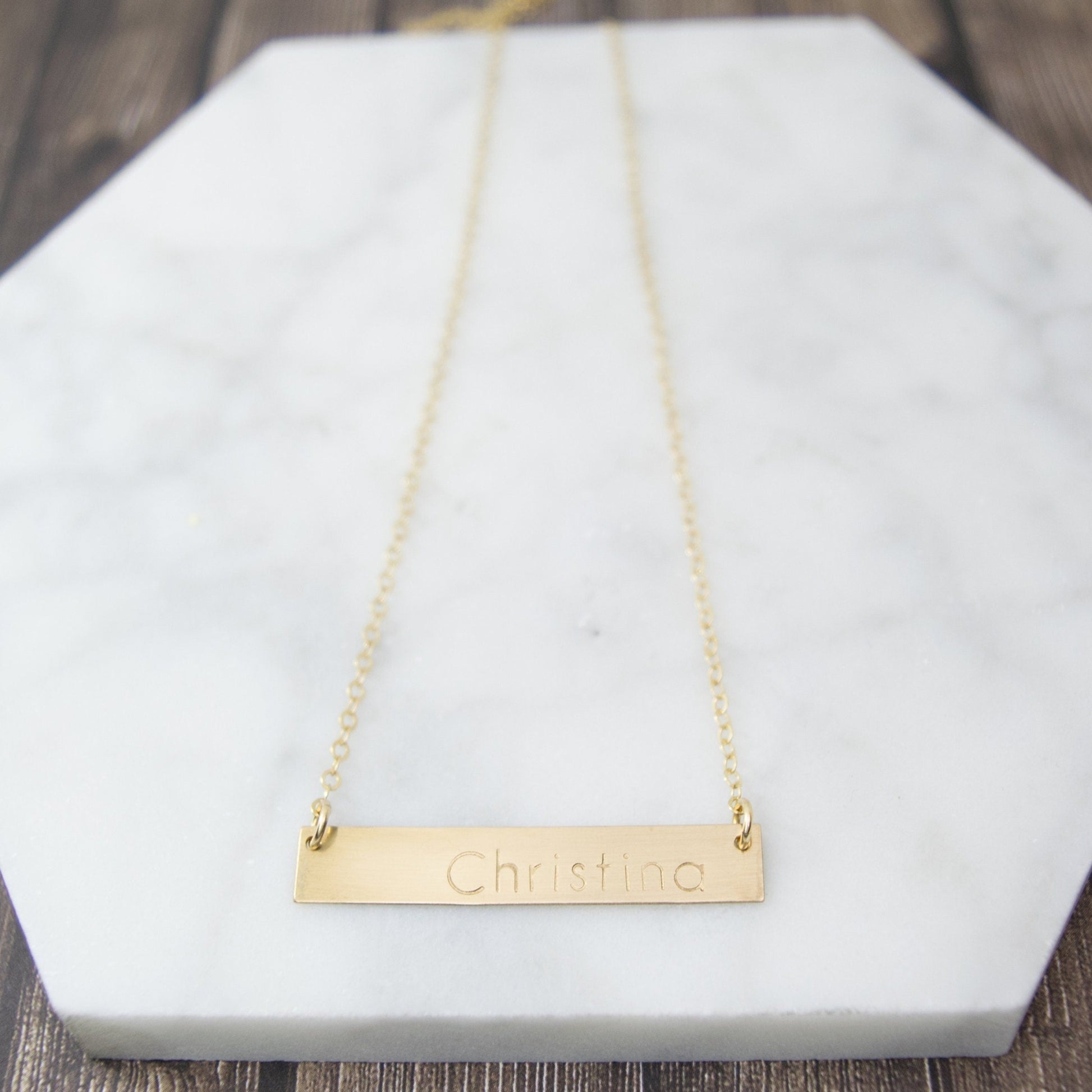 Create a truly unique piece with the Belina Bar Necklace, delicately hand-stamped with a name or message of your choice, featuring a rectangular bar pendant suspended from a dainty cable chain.