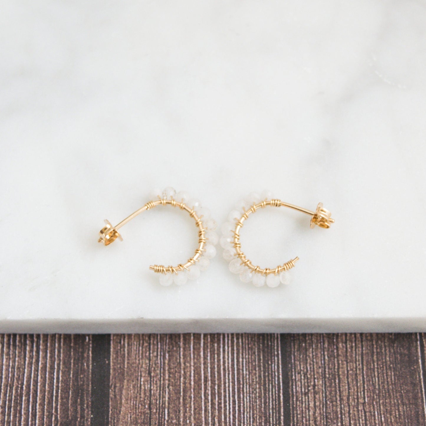 Hand-formed 14k gold-filled wire gracefully shaped into mini rounded hoops. Delicately strung with micro-faceted natural rainbow moonstone beads, these mini hoops add a polished finish to any outfit.