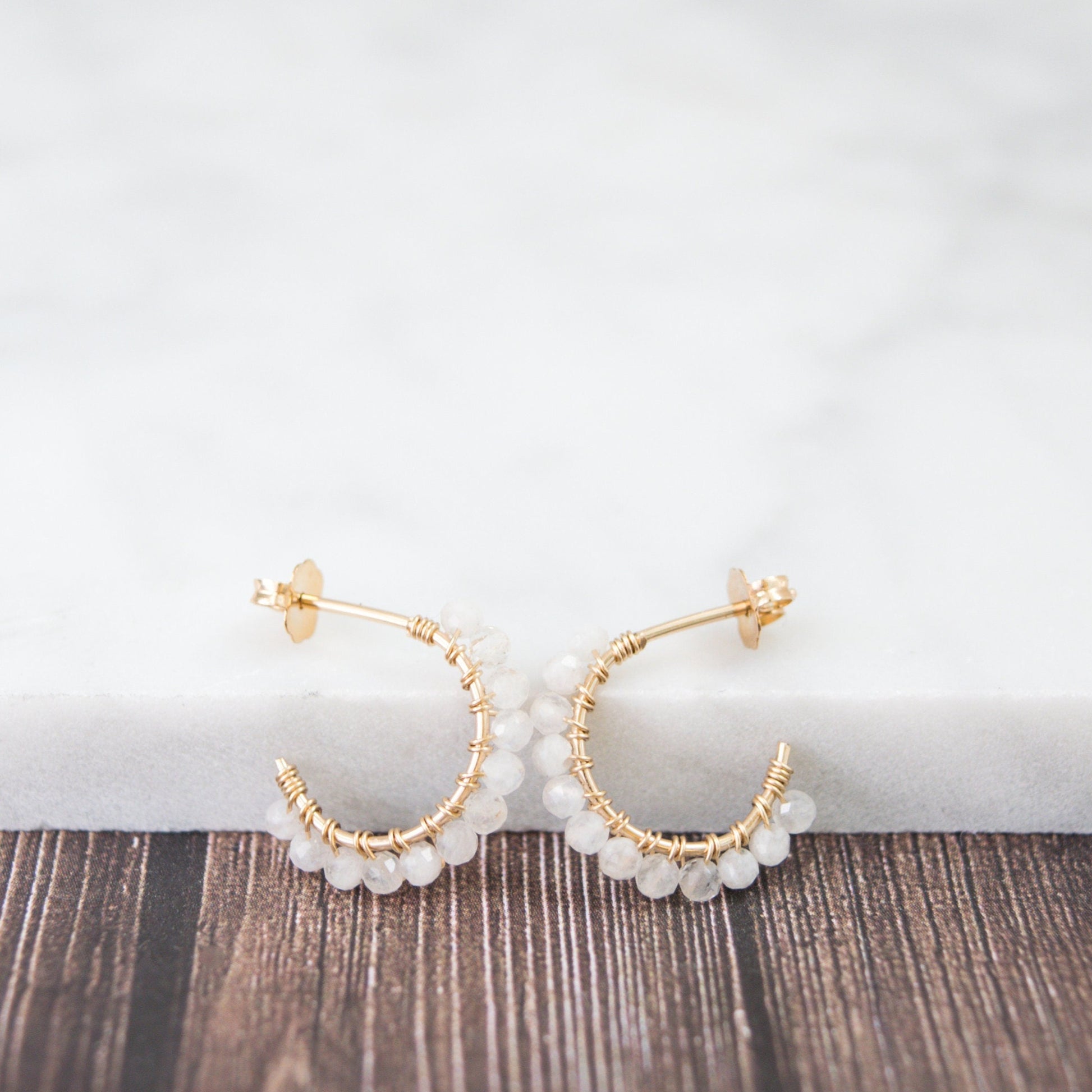 Hand-formed 14k gold-filled wire gracefully shaped into mini rounded hoops. Delicately strung with micro-faceted natural rainbow moonstone beads, these mini hoops add a polished finish to any outfit.