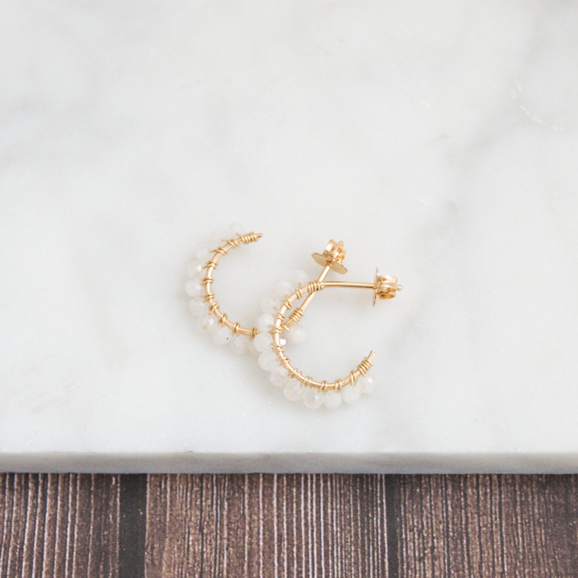 Hand-formed 14k gold-filled wire gracefully shaped into mini rounded hoops. Delicately strung with micro-faceted natural rainbow moonstone beads, these mini hoops add a polished finish to any outfit.