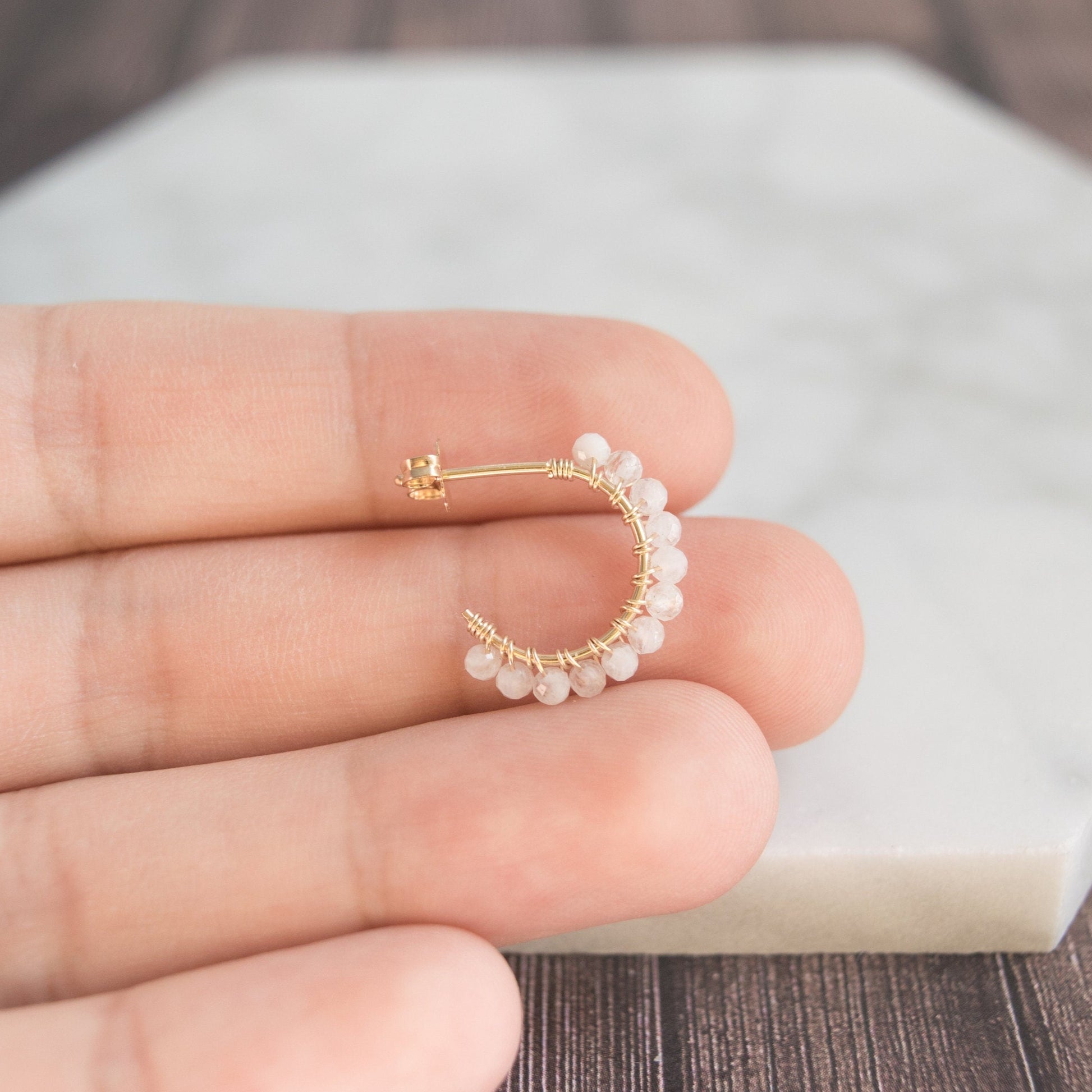 Hand-formed 14k gold-filled wire gracefully shaped into mini rounded hoops. Delicately strung with micro-faceted natural rainbow moonstone beads, these mini hoops add a polished finish to any outfit.